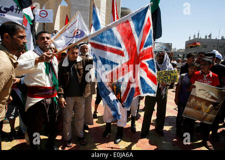 Rafah, la Palestine. 14 mai, 2014. Un palestiniens brûlent des répliques des drapeaux israéliens et britanniques au cours d'un rassemblement d'avance sur le 66e anniversaire de la Nakba, à Rafah dans le sud de la bande de Gaza le 14 mai 2014. Les Palestiniens ne marque "Nakba" (catastrophe) le 15 mai pour commémorer l'expulsion ou la fuite de quelque 700 000 Palestiniens de leurs maisons dans la guerre qui a mené à la fondation d'Israël en 1948.Photo : Abed Rahim Khatib/Pacific Press/Alamy Live News Banque D'Images