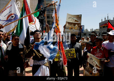 Rafah, la Palestine. 14 mai, 2014. Un palestiniens brûlent des répliques des drapeaux israéliens et britanniques au cours d'un rassemblement d'avance sur le 66e anniversaire de la Nakba, à Rafah dans le sud de la bande de Gaza le 14 mai 2014. Les Palestiniens ne marque "Nakba" (catastrophe) le 15 mai pour commémorer l'expulsion ou la fuite de quelque 700 000 Palestiniens de leurs maisons dans la guerre qui a mené à la fondation d'Israël en 1948.Photo : Abed Rahim Khatib/Pacific Press/Alamy Live News Banque D'Images