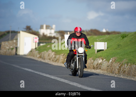 Pilote moto Tom Bray termine la dernière étape d'un 'Top' de John O'Groats à Land's End ride à Land's End, en Angleterre. Banque D'Images