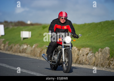 Pilote moto Tom Bray termine la dernière étape d'un 'Top' de John O'Groats à Land's End ride à Land's End, en Angleterre. Banque D'Images