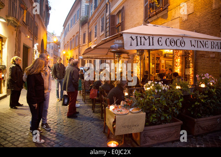 Les personnes mangeant à Mimi e Coco Wine bar restaurant en début de soirée, Rome, Italie Europe Banque D'Images