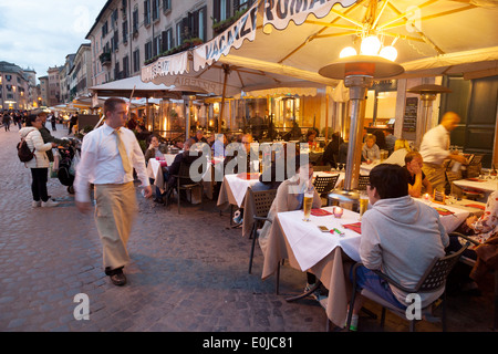 Les gens de manger dans un restaurant en début de soirée, la Piazza Navona, Rome, Italie Europe Banque D'Images