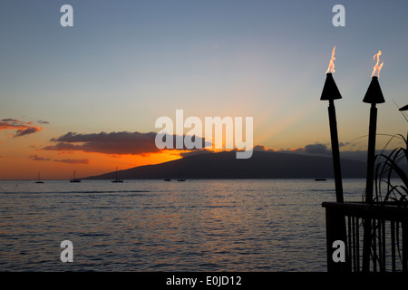 Torches Tiki et le coucher du soleil sur l'île de Maui, Hawaii Banque D'Images