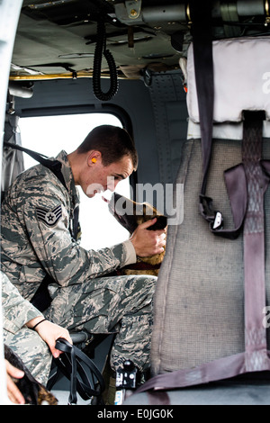 Tech. Le Sgt. Andrew Montgomery, un groupe de militaires de l'Armée de l'air de chien, console son chien à l'intérieur d'un Diesel UH-60 Blackhawk de l'Armée Banque D'Images