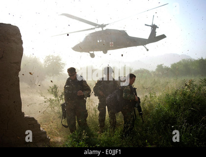 Les commandos afghans, avec l'Armée nationale afghane par le 3e Commando Le Kandak, protéger leurs visages à partir de la projection de débris après le chargement d'un Banque D'Images