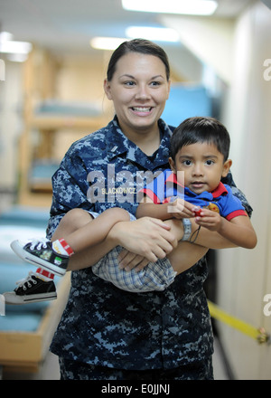 Un jeune patient se détend dans l'après-service de chirurgie avec le lieutenant J.G. Sarah Blackowicz à bord du transport maritime militaire de l'hôpital de la commande sh Banque D'Images