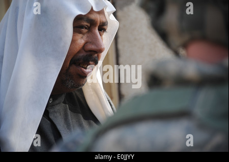 Un homme parle avec des soldats américains lors d'une mission médicale coopérative (MEC) dans Muhallah Sindabad, 979, l'est de Bagdad, Banque D'Images