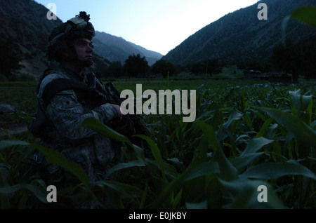 Un soldat de l'Armée américaine à partir de la 1e Bataillon, 32e Régiment d'infanterie, 10e division de montagne, des montres pour les activités de l'ennemi dans le domaine Banque D'Images