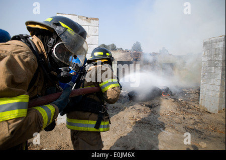 Kaboul, Afghanistan - Membres du Corps de l'air nationale afghane de l'unité de protection incendie répondre un feu intentionnellement le dans un dilapi Banque D'Images
