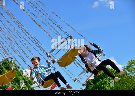 Les enfants prennent un tour sur le carrousel traditionnel dans un parc d'expositions sur le Royal Windsor Horse Show, Windsor, Berkshire, Angleterre, Royaume-Uni Banque D'Images