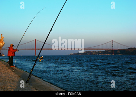 Au coucher du soleil, pêche dans le tage (Tejo) avec Monument des découvertes et du 25 avril Bridge Lisbonne Portugal Europe de l'ouest Banque D'Images