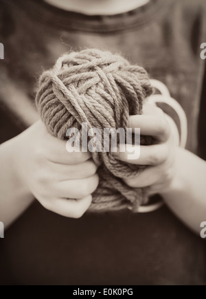 Close up of little girl holding une pelote de laine dans ses mains Banque D'Images