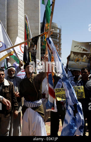 Gaza, Territoires palestiniens. 15 mai, 2014. Un palestiniens brûlent des répliques des drapeaux israéliens et britanniques au cours d'un rassemblement d'avance sur le 66e anniversaire de la Nakba, à Rafah dans le sud de la bande de Gaza le 14 mai 2014. Marque ''palestiniens'' de la Nakba (catastrophe) le 15 mai pour commémorer l'expulsion ou la fuite de quelque 700 000 Palestiniens de leurs maisons dans la guerre qui a mené à la fondation d'Israël en 1948. © Abed Rahim Khatib/NurPhoto ZUMAPRESS.com/Alamy/Live News Banque D'Images