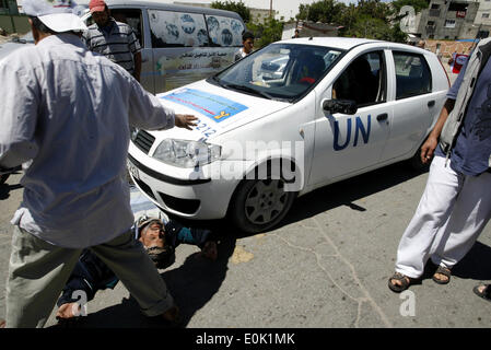 15 mai 2014 - Gaza, Palestine - un Palestinien dort en face de la voiture de l'Organisation des Nations Unies, lors d'une manifestation devant le siège de l'office de contre leur décision de réduire l'aide dans le camp de réfugiés de Rafah, dans le sud de la bande de Gaza le 15 mai 2014. L'organisation des secours et de travaux des Nations Unies pour les réfugiés de Palestine (UNRWA) a supprimé l'aide alimentaire à 9 000 familles de Gaza depuis le début de l'année, les Palestiniens a déclaré que les manifestants. (Crédit Image : © Abed Rahim Khatib/NurPhoto/ZUMAPRESS.com) Banque D'Images