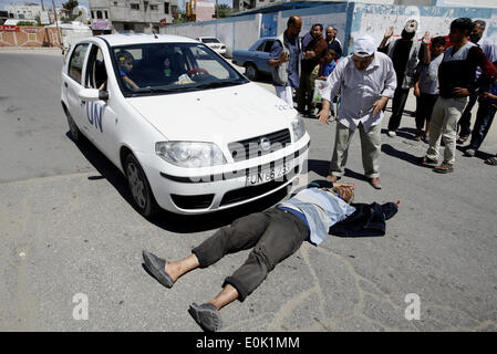 15 mai 2014 - Gaza, Palestine - un Palestinien dort en face de la voiture de l'Organisation des Nations Unies, lors d'une manifestation devant le siège de l'office de contre leur décision de réduire l'aide dans le camp de réfugiés de Rafah, dans le sud de la bande de Gaza le 15 mai 2014. L'organisation des secours et de travaux des Nations Unies pour les réfugiés de Palestine (UNRWA) a supprimé l'aide alimentaire à 9 000 familles de Gaza depuis le début de l'année, les Palestiniens a déclaré que les manifestants. (Crédit Image : © Abed Rahim Khatib/NurPhoto/ZUMAPRESS.com) Banque D'Images