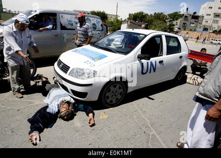 15 mai 2014 - Gaza, Palestine - un Palestinien dort en face de la voiture de l'Organisation des Nations Unies, lors d'une manifestation devant le siège de l'office de contre leur décision de réduire l'aide dans le camp de réfugiés de Rafah, dans le sud de la bande de Gaza le 15 mai 2014. L'organisation des secours et de travaux des Nations Unies pour les réfugiés de Palestine (UNRWA) a supprimé l'aide alimentaire à 9 000 familles de Gaza depuis le début de l'année, les Palestiniens a déclaré que les manifestants. (Crédit Image : © Abed Rahim Khatib/NurPhoto/ZUMAPRESS.com) Banque D'Images