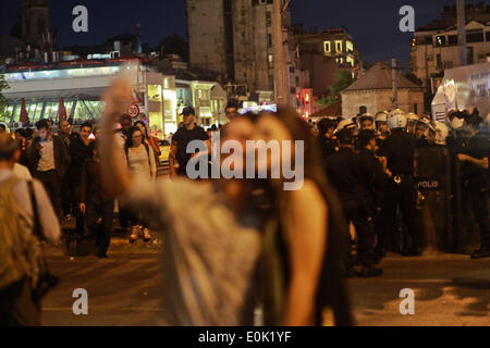 15 mai 2014 - Istanbul, Turquie - un couple turc prend une photo d'eux-mêmes avec les policiers turcs en arrière-plan sur la place Taksim, au cours d'une protestation contre la catastrophe minière dans le Soma, la Turquie qui a tué plus de 245 personnes en turc 15 mai 2014. La Turquie a déclaré trois jours de deuil national le 14 mai, le bilan de la pire catastrophe minière en plus de deux décennies a atteint plus de 245, avec la crainte que le nombre pourrait grimper beaucoup plus haut. Banque D'Images