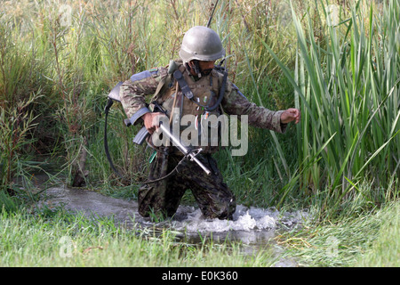 SANGIN, dans la province d'Helmand, en Afghanistan - Un soldat afghan, de la 4e, 2e Kandak Tolay, 215e Corps, sloshes à travers un canal w Banque D'Images