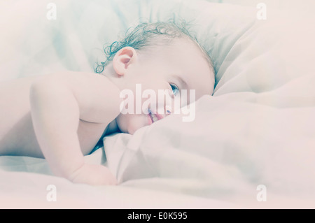 Portrait 15 mois baby boy lying on bed smiling Banque D'Images