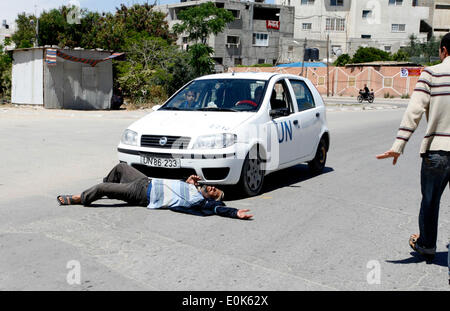 Rafah, la Palestine. 15 mai, 2014. Un Palestinien dort en face de la voiture de l'Organisation des Nations Unies, lors d'une manifestation devant le siège de l'office de contre leur décision de réduire l'aide dans le camp de réfugiés de Rafah, dans le sud de la bande de Gaza le 15 mai 2014. L'organisation des secours et de travaux des Nations Unies pour les réfugiés de Palestine (UNRWA) a supprimé l'aide alimentaire à 9 000 familles de Gaza depuis le début de l'année, les Palestiniens a déclaré que les manifestants. Credit : Abed Rahim Khatib/PACIFIC PRESS/Alamy Live News Banque D'Images