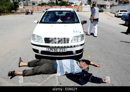 Rafah, la Palestine. 15 mai, 2014. Un Palestinien dort en face de la voiture de l'Organisation des Nations Unies, lors d'une manifestation devant le siège de l'office de contre leur décision de réduire l'aide dans le camp de réfugiés de Rafah, dans le sud de la bande de Gaza le 15 mai 2014. L'organisation des secours et de travaux des Nations Unies pour les réfugiés de Palestine (UNRWA) a supprimé l'aide alimentaire à 9 000 familles de Gaza depuis le début de l'année, les Palestiniens a déclaré que les manifestants. Credit : Abed Rahim Khatib/PACIFIC PRESS/Alamy Live News Banque D'Images