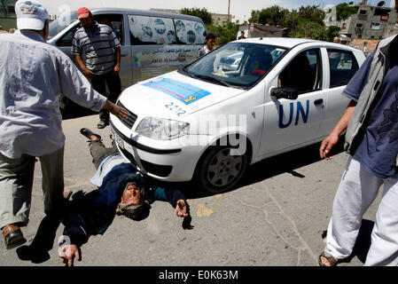 Rafah, la Palestine. 15 mai, 2014. Un Palestinien dort en face de la voiture de l'Organisation des Nations Unies, lors d'une manifestation devant le siège de l'office de contre leur décision de réduire l'aide dans le camp de réfugiés de Rafah, dans le sud de la bande de Gaza le 15 mai 2014. L'organisation des secours et de travaux des Nations Unies pour les réfugiés de Palestine (UNRWA) a supprimé l'aide alimentaire à 9 000 familles de Gaza depuis le début de l'année, les Palestiniens a déclaré que les manifestants. Credit : Abed Rahim Khatib/PACIFIC PRESS/Alamy Live News Banque D'Images