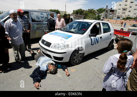 Rafah, la Palestine. 15 mai, 2014. Un Palestinien dort en face de la voiture de l'Organisation des Nations Unies, lors d'une manifestation devant le siège de l'office de contre leur décision de réduire l'aide dans le camp de réfugiés de Rafah, dans le sud de la bande de Gaza le 15 mai 2014. L'organisation des secours et de travaux des Nations Unies pour les réfugiés de Palestine (UNRWA) a supprimé l'aide alimentaire à 9 000 familles de Gaza depuis le début de l'année, les Palestiniens a déclaré que les manifestants. Credit : Abed Rahim Khatib/PACIFIC PRESS/Alamy Live News Banque D'Images