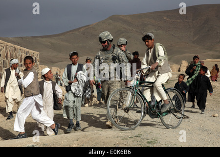 Les soldats de l'Armée américaine du 450e Bataillon de marche des affaires civiles des enfants afghans à travers le village de HeydarKheyl, Sayed-A Banque D'Images