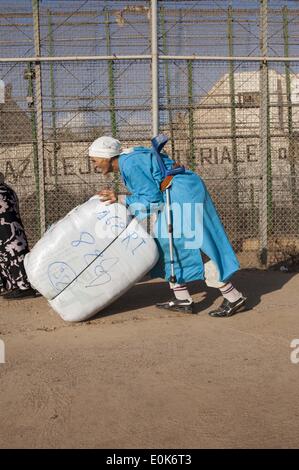 Melilla, Melilla, Espagne. 27 Sep, 2011. Il est 6 h 30, des centaines de personnes sont concentrées à la frontière du quartier chinois de la de la ville autonome de Melilla entre l'Espagne et le Maroc. Ils sont en attente pour les véhicules qui amènent jusqu'à faisceaux lourds varie de 40 à 50kg mais parfois atteint 70 kg de poids. Une écrasante majorité de ces transporteurs sont des femmes (ladies mule). Ils transporter de lourds colis à une plate-forme de ciment où marqués et triés, maintenant, c'est lors du combat de plus de problèmes qu'il y a certains qui veulent s'infiltrent dans la ligne d'attente. À partir de 12:00 à traverser la b Banque D'Images