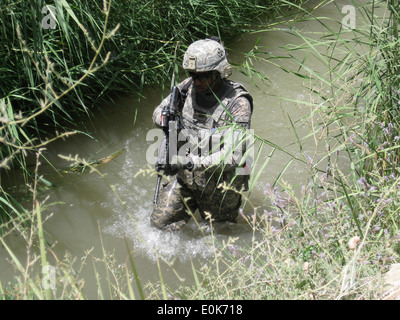 Un soldat américain du 1er Bataillon, 12e Régiment d'infanterie, patauge à travers une rivière au cours de l'opération à l'ourlet 20 juillet dans le tunnel Banque D'Images