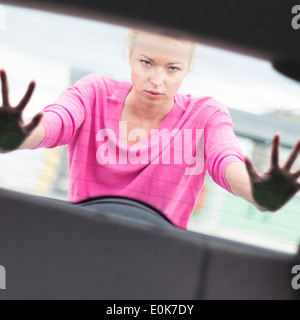 Femme poussant une voiture. Banque D'Images