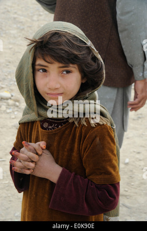 La province de KHOWST, l'Afghanistan - une jeune fille attend de recevoir une couverture à partir de la Police nationale afghane pendant les gouvernements provinciaux Reconstru Banque D'Images