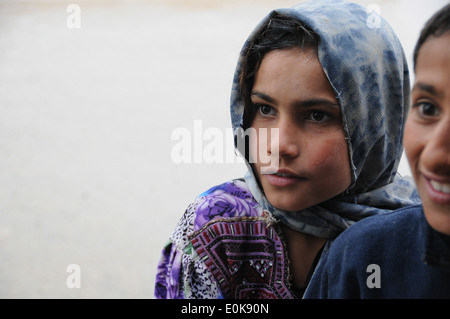 Une jeune fille Farahi regarde son frère et ses amis parler avec force de sécurité pour les membres de l'équipe de reconstruction provinciale Plateau Banque D'Images