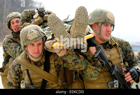 Marines affectés à l'équipe de sécurité antiterroriste de la Flotte du Pacifique de la société, 2e Peloton, transporter un blessé sur une civière tandis que condu Banque D'Images