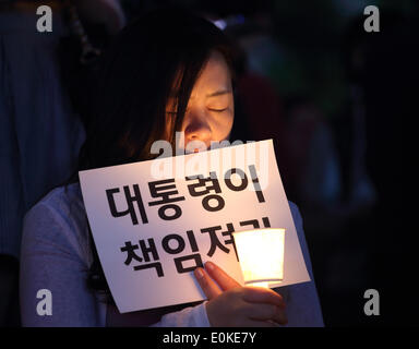 Séoul, Corée du Sud. Le 15 mai 2014. Un participant est titulaire d'une bougie lors d'une manifestation tenue à dénoncer gouvernement après les Sewol naufrage ferry au large de la côte sud-ouest de la Corée du Sud, près de l'île de Jindo le 16 avril 2014, au Plaza, Séoul, Corée du Sud, le jeudi 15 mai 2014. Des centaines de personnes ont exigé le jeudi que le président Park Geun-Hye prendre la responsabilité de la tragédie qui a causé plus de 300 morts ou disparus. Le signe se lit,'Président prendre la responsabilité'. Credit : Jaewon Lee/Alamy Live News Banque D'Images