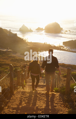 Un couple descend l'escalier en bois et le sable en fin d'après-midi au soleil Sutro Baths à San Francisco, Californie. Banque D'Images