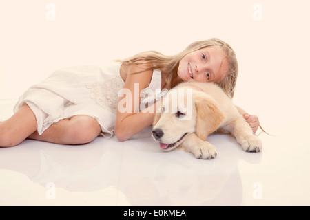 Animal girl hugging dog Labrador doré Banque D'Images