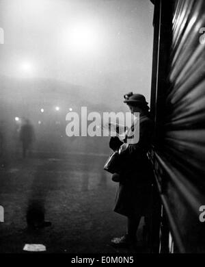 Une femme attendant son train dans le brouillard à Victoria Station Banque D'Images
