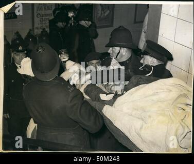 Avril 04, 1953 - 9 tués dans la catastrophe du Tube : Neuf personnes ont été connus aujourd'hui d'avoir été tués dans la ligne Central catastrophe à Stratford tube hier soir, le pire dans l'histoire de l'underground de Londres. Photo montre dix heures après l'accident, des policiers et une ambulance homme porter l'un des blessés aujourd'hui. Banque D'Images