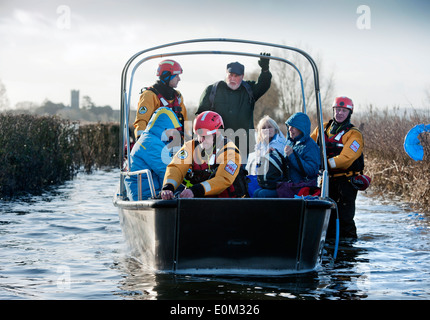Les inondations sur les Somerset Levels - les résidents de Muchelney approchant Langport sur un bateau monté par un Devon et Somerset Fire Cheminée Banque D'Images