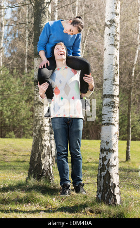 Couple heureux dans la nature. Young man carrying fille sur ses épaules. Banque D'Images