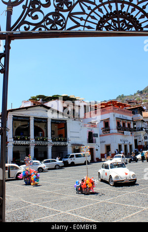 Vue sur la Plaza Borda, la place principale ooking en fer forgé à travers les portes de l'église Santa Prisca, Taxco, Mexique Banque D'Images