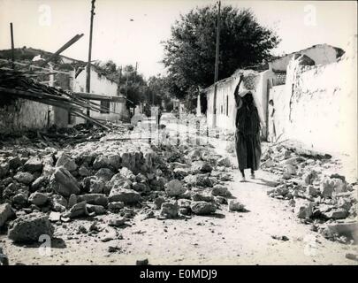 Le 14 septembre, 1954 - Scènes DU SÉISME EN ALGÉRIE : UNE FEMME AUTOCHTONE PORTANT UN PANIER SUR SA TÊTE DANS LA MANIÈRE ARABE MARCHE AU MILIEU DES RUINES DANS UN VILLAGE RAVAGÉ PAR LE SÉISME. Banque D'Images