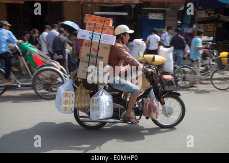 Motocycliste chargé avec des paquets dans Hoi An Vietnam Banque D'Images