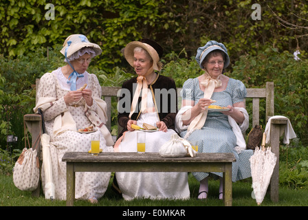 3 femmes en tenue costume Régence dans le jardin de maison de Jane Austen à Chawton, près de Alton, Hampshire, Royaume-Uni. Banque D'Images