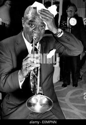 Louis Armstrong d'essuyer sa tête tout en jouant de la trompette Banque D'Images