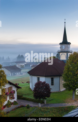 Vue du Brassus, un petit village au nord de la Suisse, avec un épais brouillard tôt le matin dans une journée d'hiver. Banque D'Images