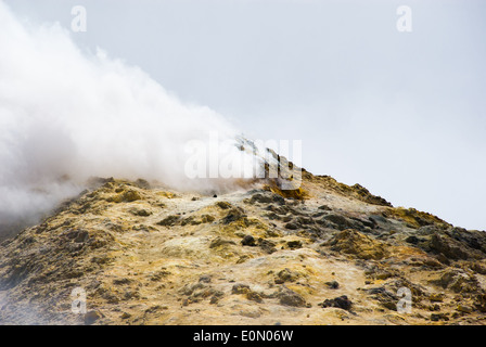 Sur le sommet de l'etna la roche est couverte de soufre et est devenu jaune, nuage de gaz toxique se propager du cratère