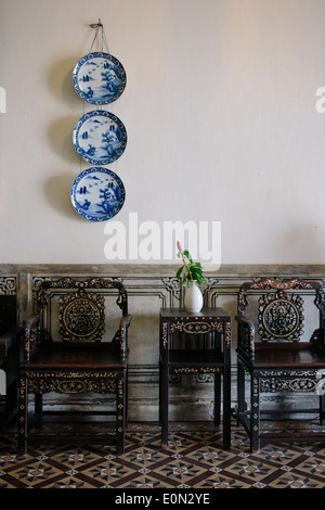 Intérieur détail tourné à l'intérieur de Cheong Fatt Tze mansion finement sculptés de chaises et table en dessous de trois plaques de suspension Banque D'Images