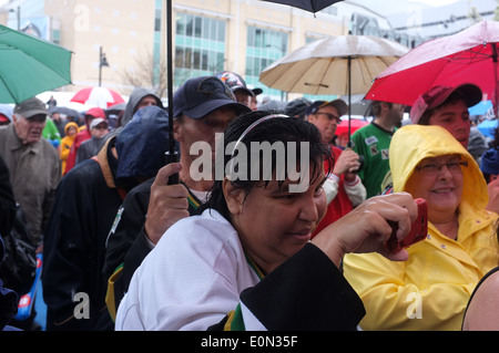 La foule se tenir sous les parasols dans la pluie. Banque D'Images